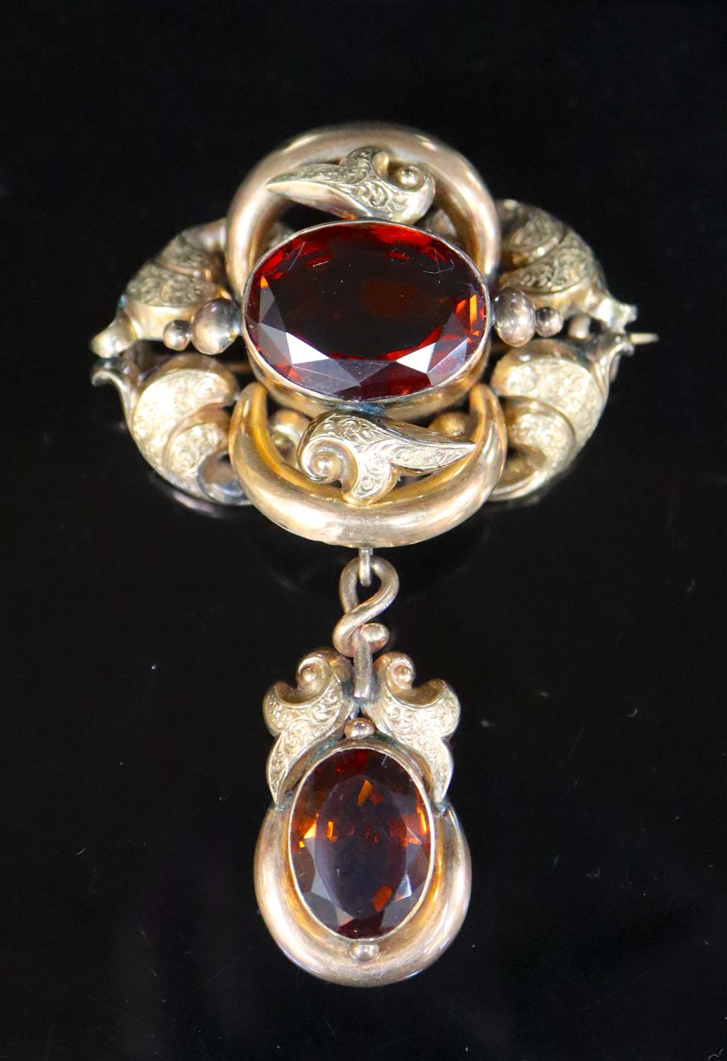 A Victorian engraved gold and two stone oval cut citrine set scrolling drop brooch,